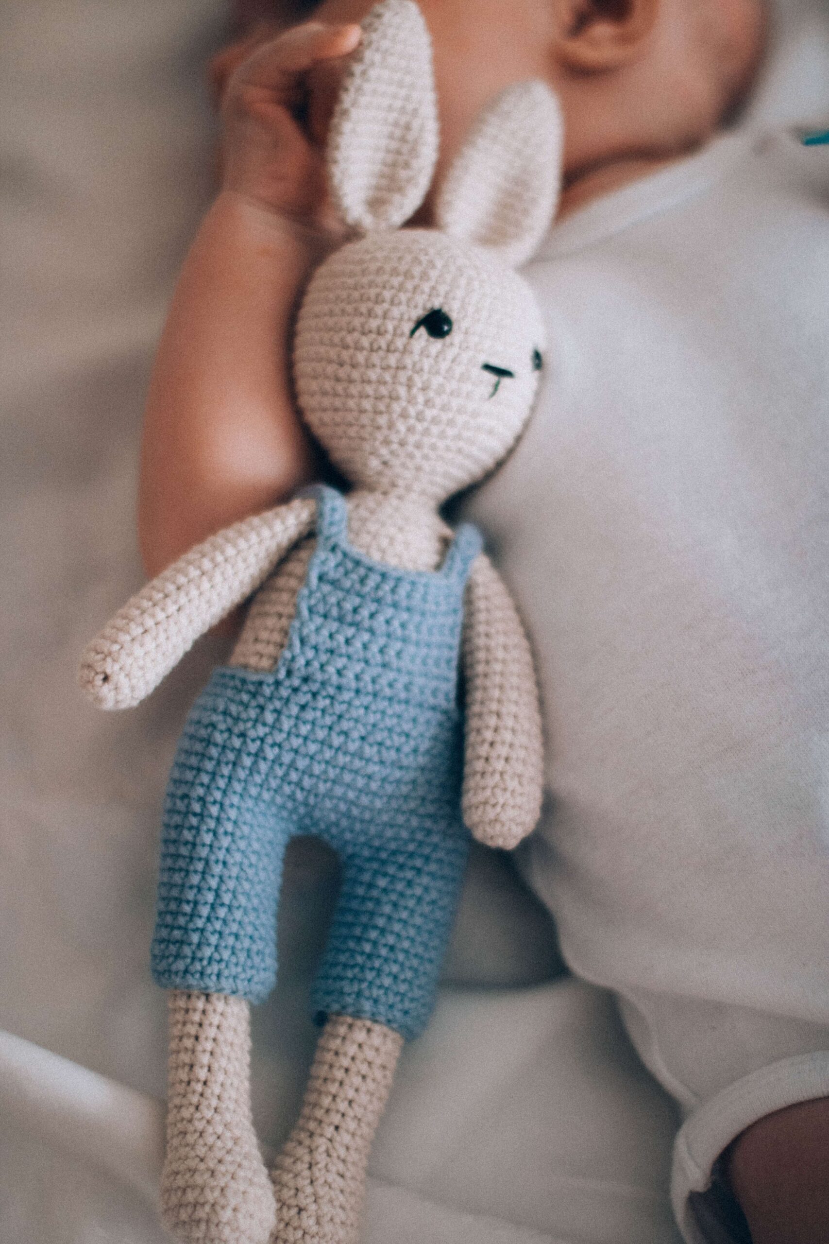 Stuffed rabbit toy in crib with baby