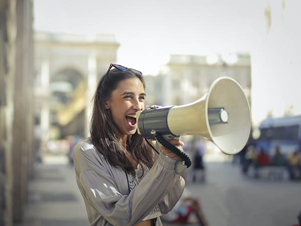 Woman shouting in a bull horn.