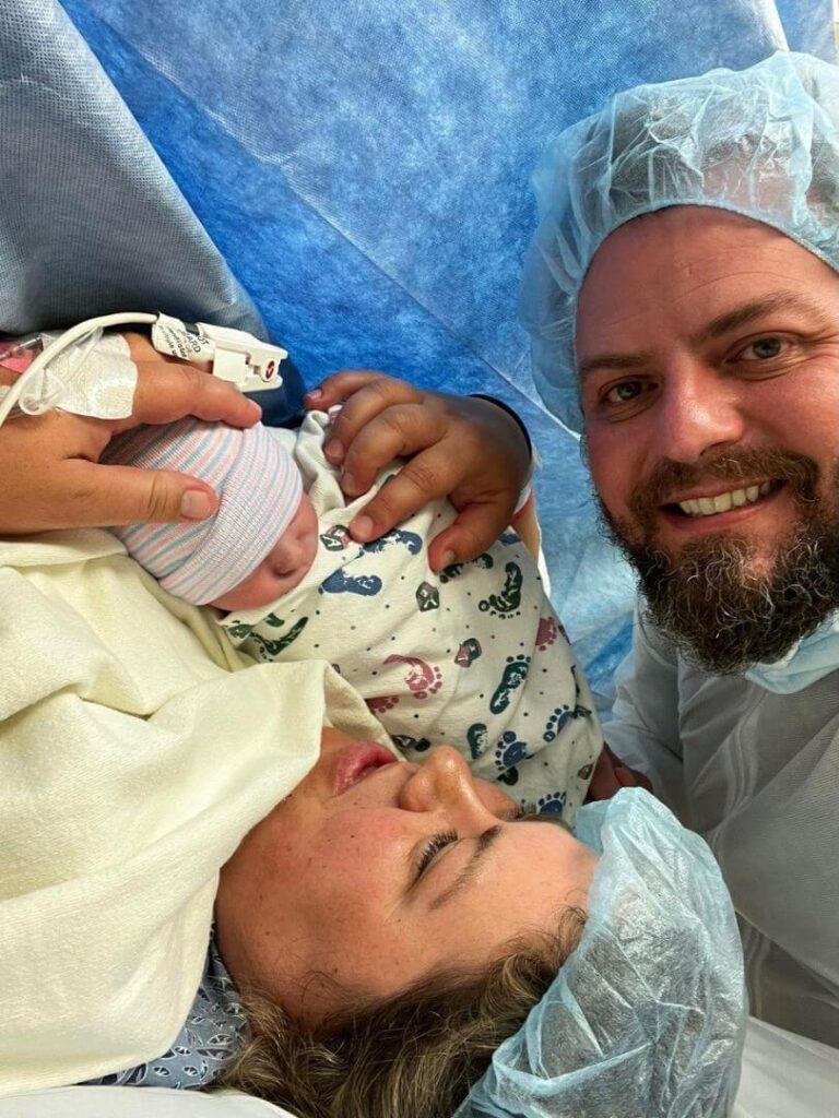 mother and father holding their successful IVF baby after birth